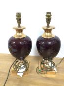 A pair of modern Valsan table lamps, of baluster form, with oxblood glazed bodies and gilt bases (