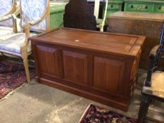 A teak chest, with panelled hinged top and front, sides and back, interior with brass plaque