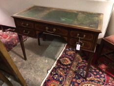 An Edwardian mahogany writing table, the rectangular top with tooled leather writing surface,