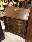 A Georgian mahogany bureau, the fall front enclosing an arrangement of drawers and pigeonholes,