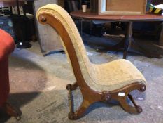 A Victorian nursing chair, with a scroll back and seat, on scroll supports united by turned