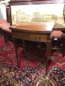 An Edwardian Georgian style card table, the bow front swivel top over a baize top, fitted two frieze