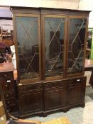 A Georgian inspired breakfront bookcase, the moulded cornice above three glazed doors with