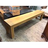 A modern oak bench, the rectangular top on straight square supports (47cm x 180cm x 35cm)