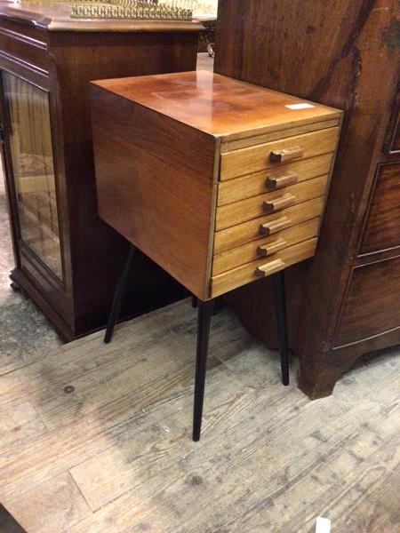 A mid century teak chest of drawers, the rectangular top above six long narrow drawers, on splay