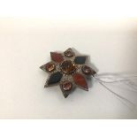 A white metal brooch set paste stones and inlaid polished stones, of star shape (6cm)