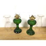 A pair of green glass oil lamps, complete with shades (lamp: 24cm excluding shade)