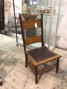 An Arts & Crafts inspired first half of 20thc nursing chair with comb and plank back, leather