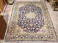 A fine Persian Kashan rug with central floral medallion within multiple floral borders, indigo and
