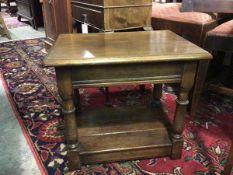 An oak occasional table with rectangular top and moulded edge, on turned supports united by