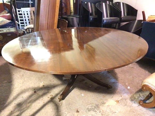 A mahogany Regency style circular dining table, the top with reeded edge on turned supports and four