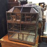 A large decorative Victorian bird cage, the sarcophagus shaped top with coloured glass to corners,