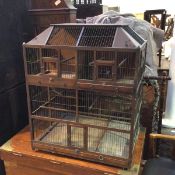 A large decorative Victorian bird cage, the sarcophagus shaped top with coloured glass to corners,