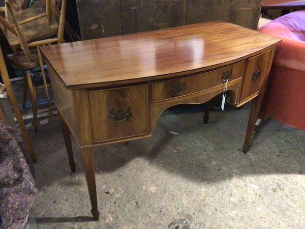 An Edwardian mahogany desk or dressing table, with bow front, fitted single frieze drawer flanked by