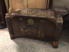 A Chinese camphorwood chest, the hinged tiered carved top depicting traditional Chinese scenes, with