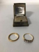 Two yellow metal rings, one a wedding band (S), the other set five paste stones