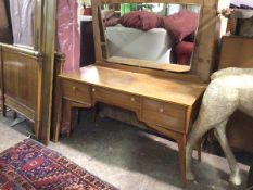 A mid century dressing table, stamped AC Handcraft Quality Furniture, the shaped mirror above a