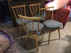 A set of four Ercol beech and elm side chairs, with turned spindle backs, with squab cushions, on