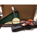 A George Formby banjo (55cm) with travelling case and a violin bearing stamp to interior,