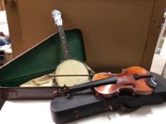 A George Formby banjo (55cm) with travelling case and a violin bearing stamp to interior,