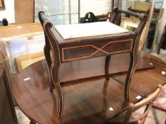 An Edwardian ebonised piano stool with raised turned handles above a later upholstered hinged