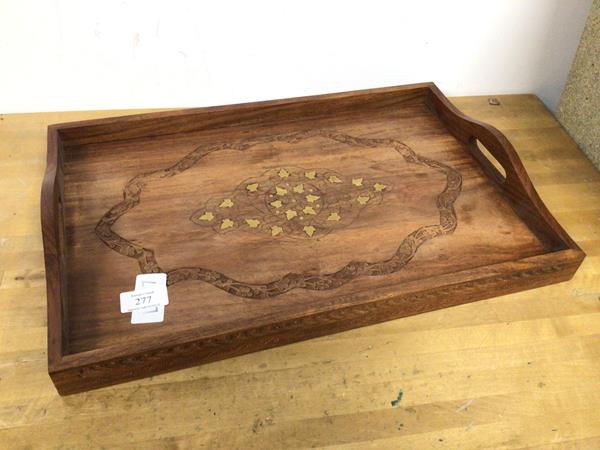 An Indian drinks tray, the raised edge with pierced handles to side, the top with carved foliate