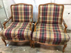 A pair of modern Louis XV inspired bergeres, with plaid upholstered backs and seat cushions, on