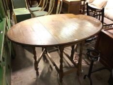 A 1930s/40s oak gateleg table, the top with moulded edge on barley twist supports united by