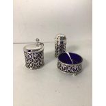 A silver condiment set including a pepperette (7cm), mustard pot and salt dish, all with blue