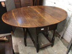 A Georgian oak Pembroke table, the oval top with rounded edges, fitted single drawer to short