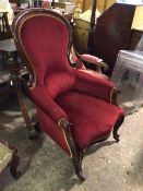 A Victorian mahogany library armchair, the spoon back with scrolled sides in a deep red