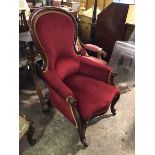 A Victorian mahogany library armchair, the spoon back with scrolled sides in a deep red