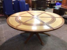 A modern extending dining table, the circular top with six radiating leaves, on a six footed