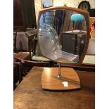 A mid century style dressing table mirror, the rounded glass within a shaped frame, on metal support