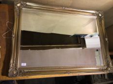 A modern wall mirror, the bevelled glass within a gilt composition rectangular frame (75cm x 106cm)