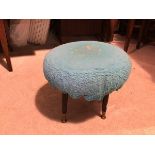 A 1960s style footstool with later blue upholstery, on outswept tapering supports terminating in