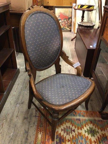 A late 19thc/early 20thc nursing chair, the circular back with carved top above an upholstered
