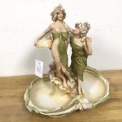 A Royal Dux centrepiece, with two Beauties before a vase, on naturalistic base (38cm x 37cm x
