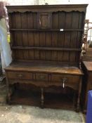 A George II style dresser, the two tier plate rail with small cupboard to centre, on base with