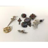 A collection of Scottish brooches including polished stone, stag's head, thistles etc. (8), and