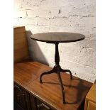 A 1930s/40s mahogany wine table, the oval top on turned tripod support terminating in spade feet (