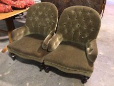 A pair of late Victorian library armchairs, with button backs and arms, in an olive green