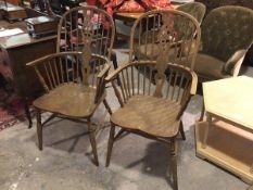 Two wheel back Windsor armchairs, in oak and elm, with saddle style seats, on turned supports united