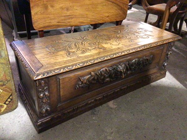 An early 20thc oak cassone, with foliate carved top with moulded edge, the front with greenman,