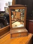 A 1920s/30s hanging mirror and shelf, the rectangular glass in oak frame above a shelf with single