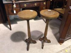 A pair of 1920s plant stands, the circular tops with reeded edges on turned stems and tripod base (