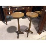 A pair of 1920s plant stands, the circular tops with reeded edges on turned stems and tripod base (
