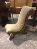 A Victorian nursing chair with a scroll back and seat, on scroll supports united by turned