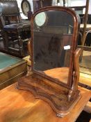 A mid to late 19thc mahogany dressing table mirror, the domed glass within a moulded frame, on