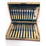 An Edwardian cutlery canteen with a set of twelve knives and forks, with bone handles (canteen: